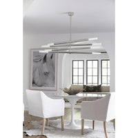Modern Wick Chandelier in polished nickel with four swiveling arms and frosted acrylic bulb covers over a dining table.