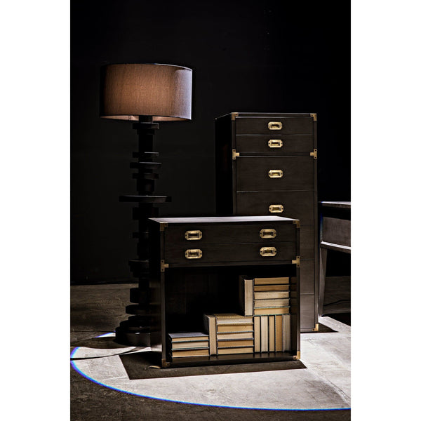 Wilton black steel floor lamp with stacked metal discs and a dark shade, next to black wood furniture.