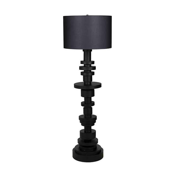 Wilton black steel floor lamp with stacked variegated metal discs base and a dark fabric drum shade.