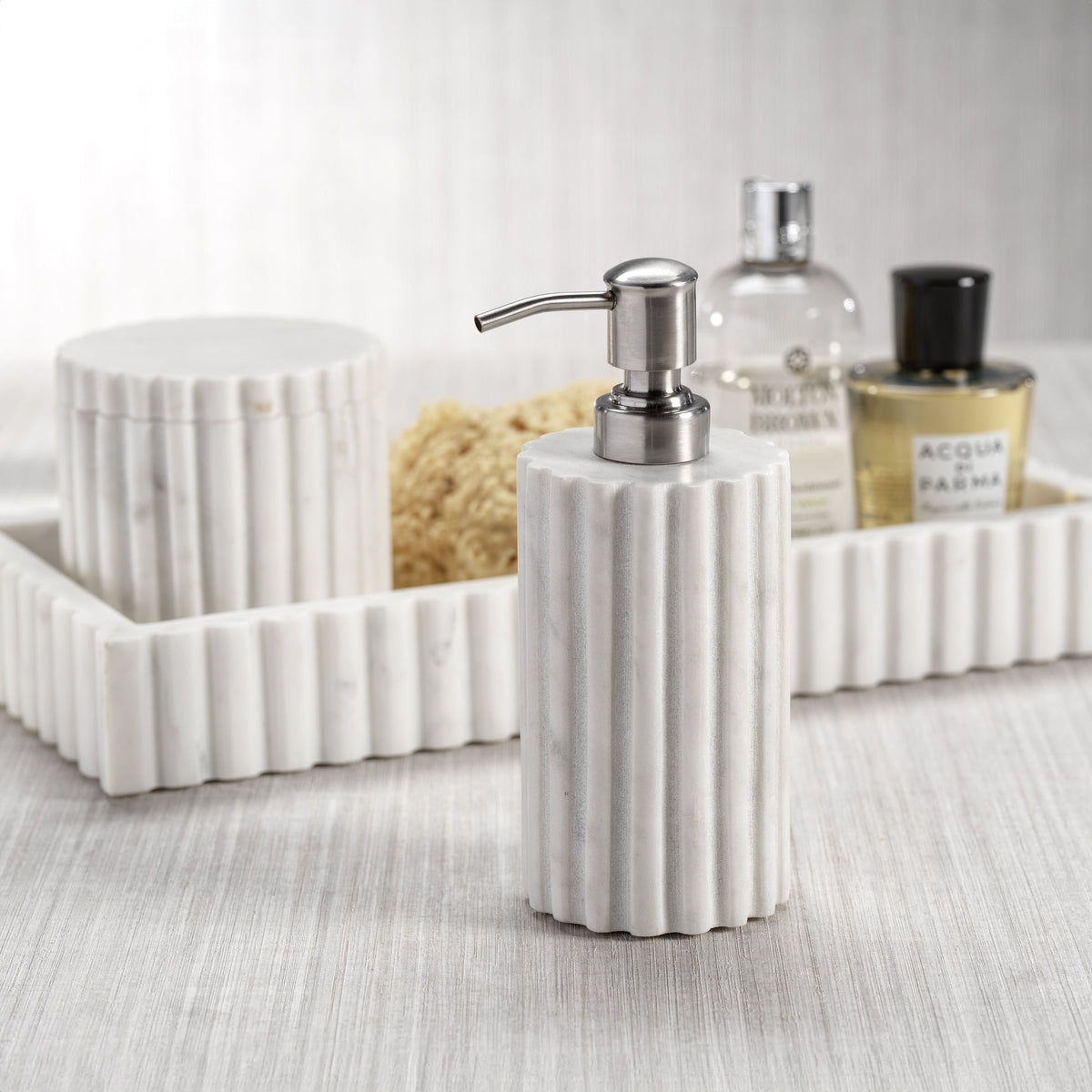 White ribbed soap dispenser with a pump on a bathroom counter.