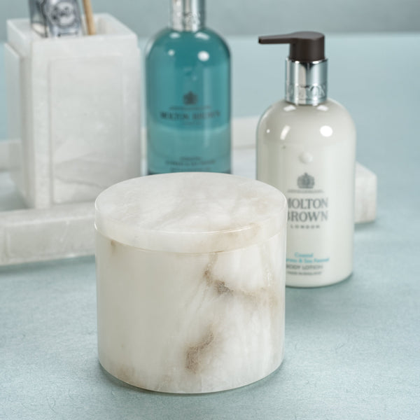 Marble-textured container and bottles with 'Molton Brown' branding on a light blue surface.