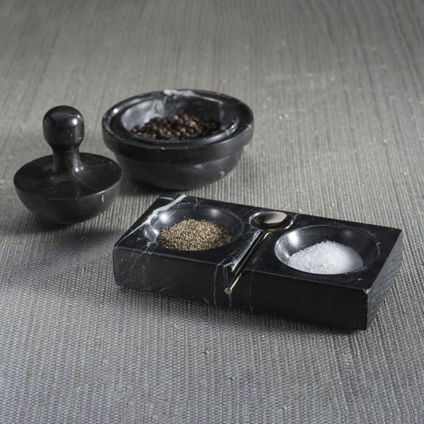 Black stone salt and pepper shaker set on a textured surface
