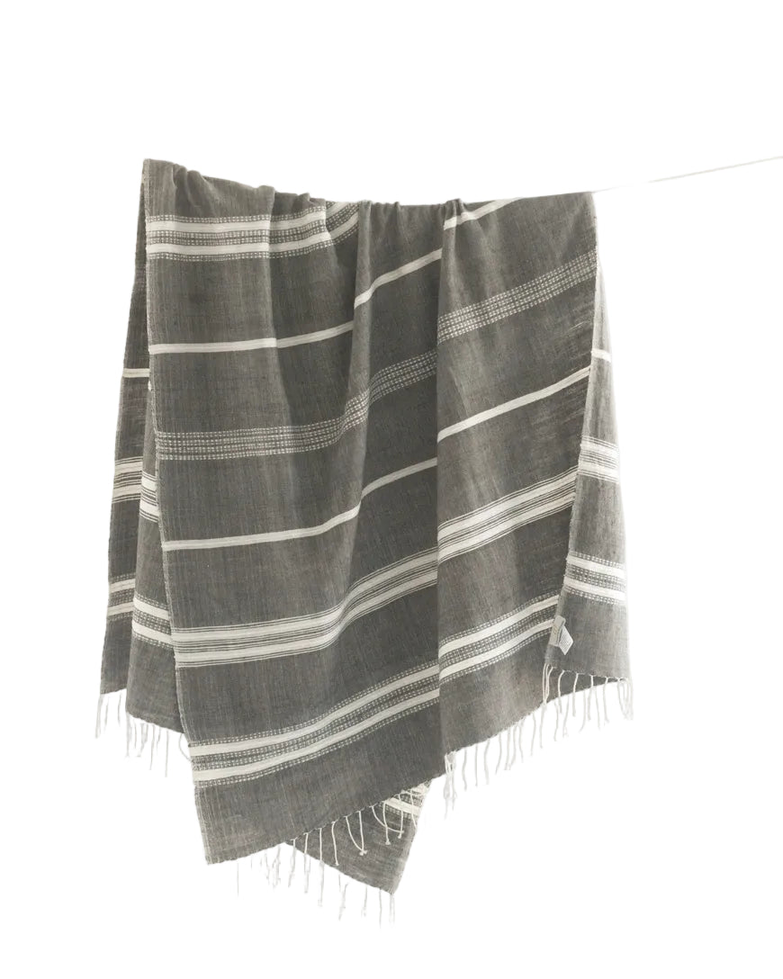 Striped towel hanging on a line against a white background